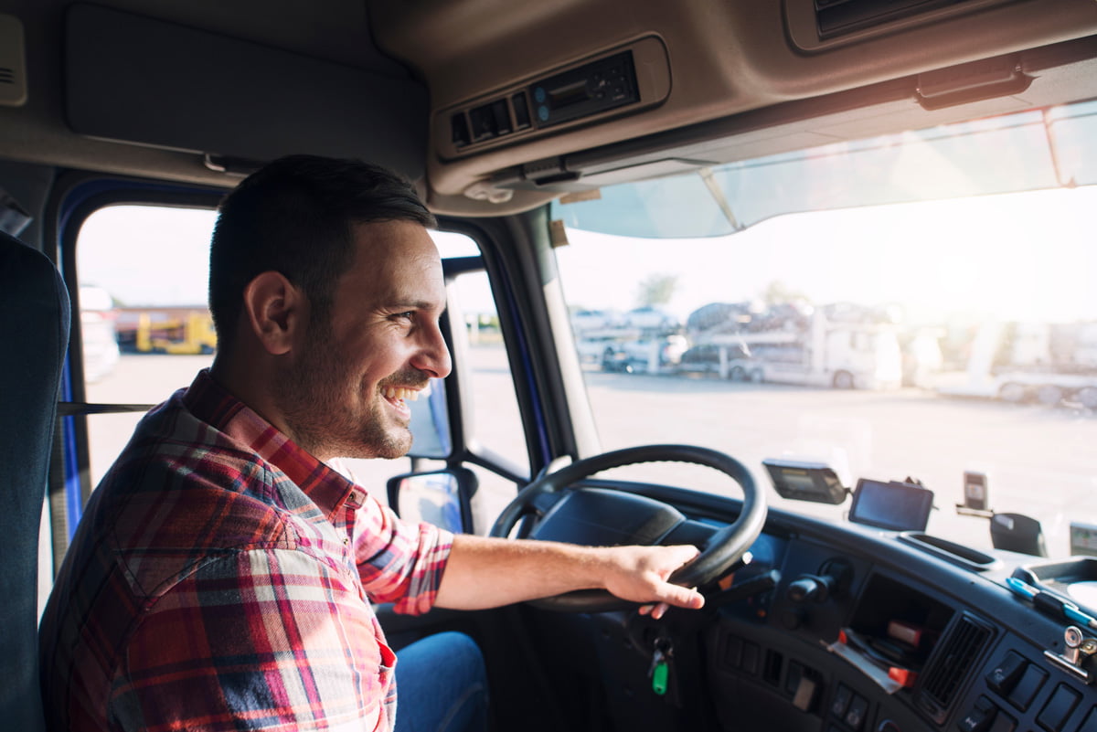 A smiling man driving a truck in El Paso.
